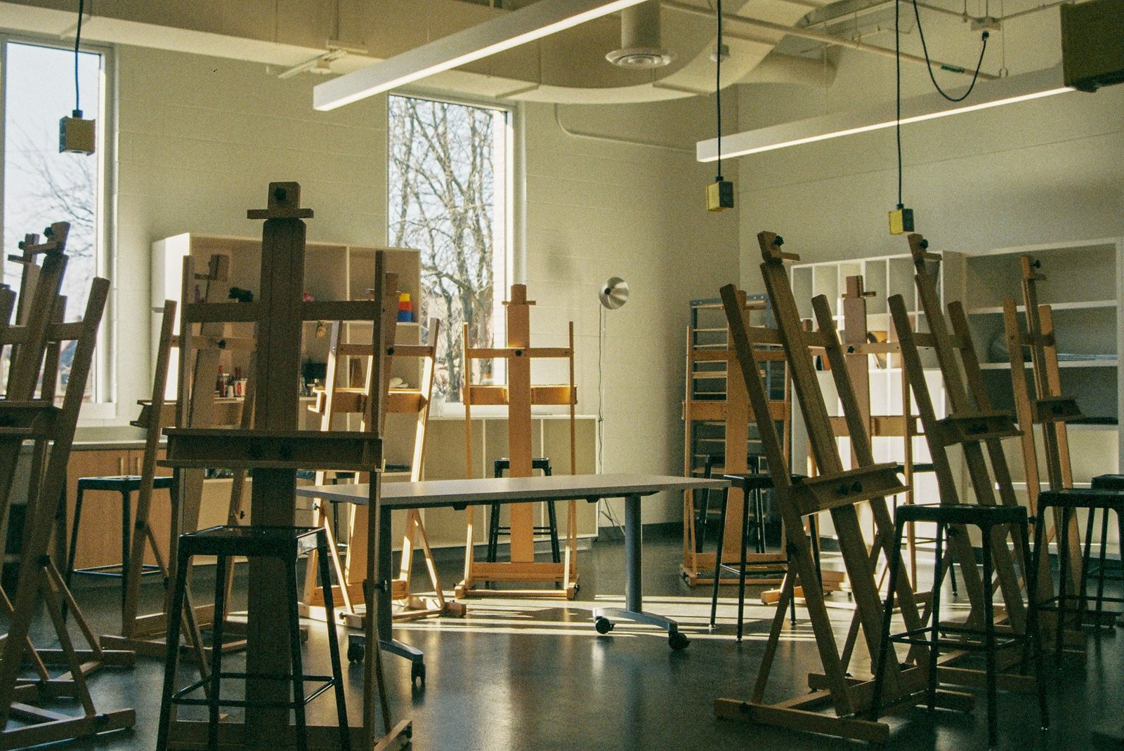 Atelier d'art lumineux, chevalets alignés devant de grandes fenêtres