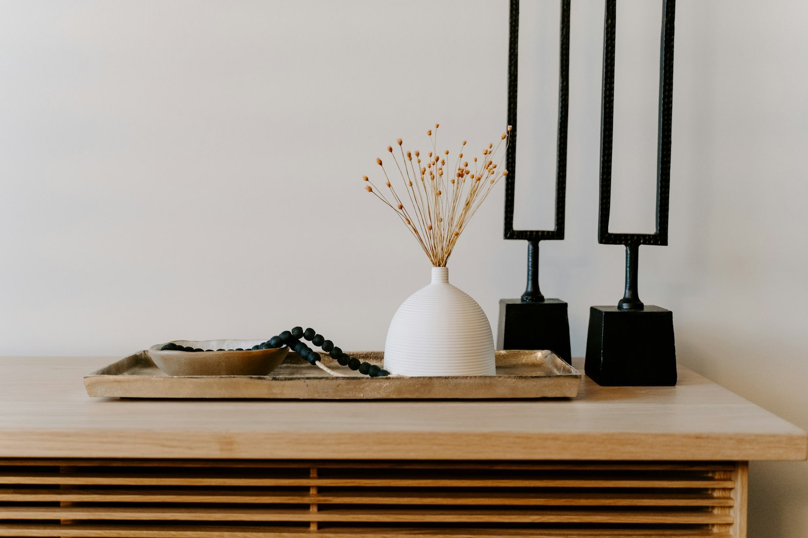 Bougeoirs en métal noir et vase blanc sur une console