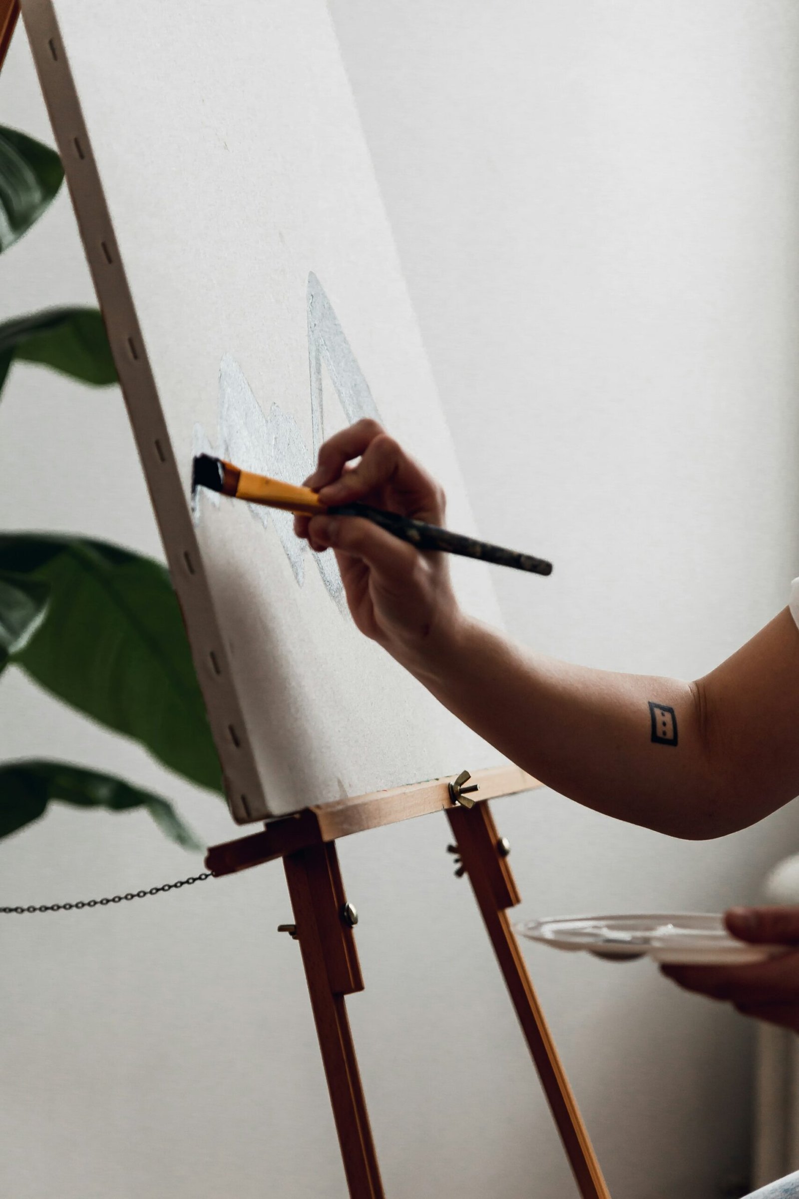 Main peignant une toile à l'acrylique