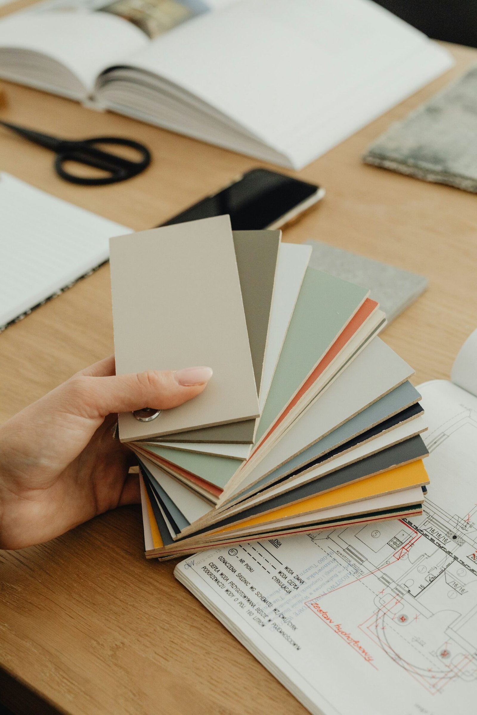 Nuancier de couleurs tenu au-dessus de plans d'architecte